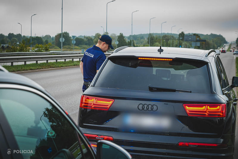 Valsts policijas automašīna un policijas darbinieki.
